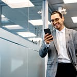 empresário latino-americano usando telefone celular em um corredor.